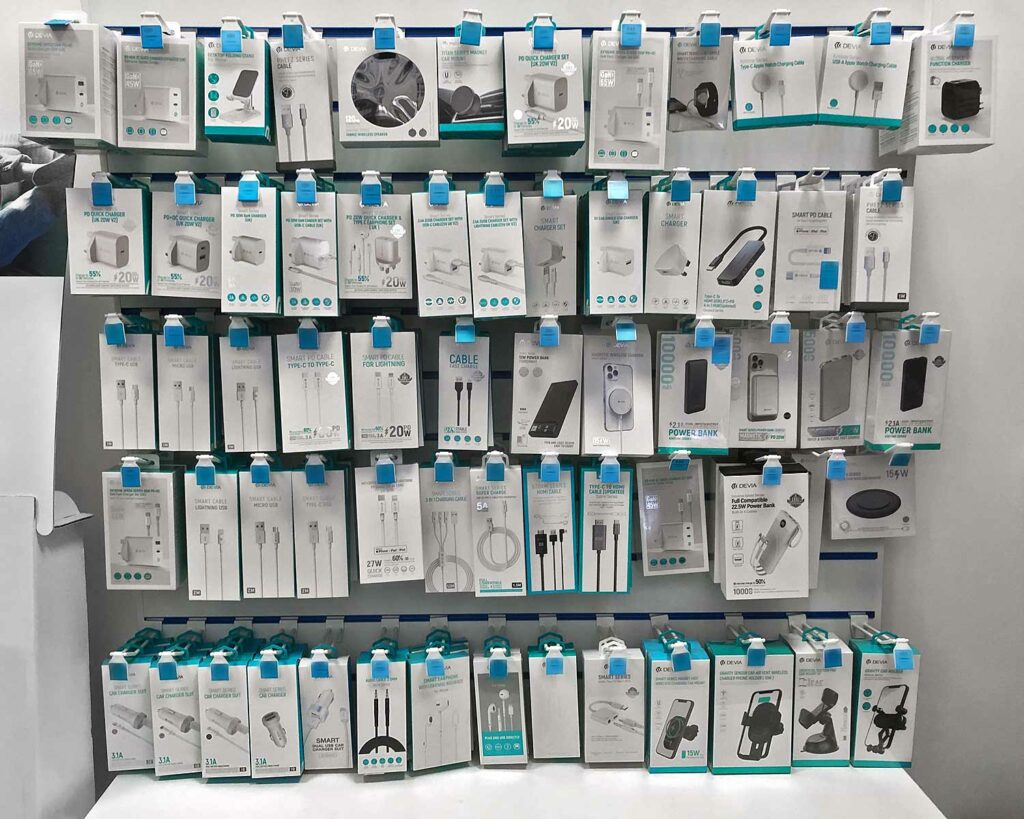 Shelf displaying a range of Devia smartphone chargers and other accessories